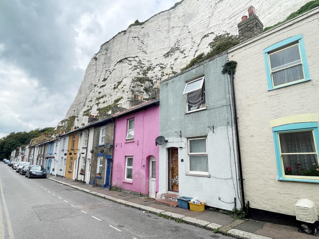 Lot: 7 - TWO-BEDROOM TERRACE HOUSE - Row of terrace houses with white cliffs in background